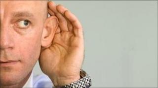 Man with his hand to his ear