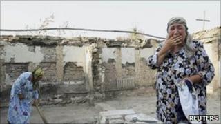 An Uzbek woman in the ruins of her house