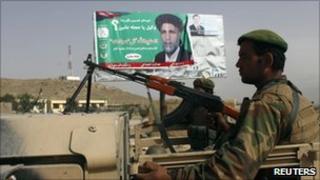 Afghan National Army soldiers in a truck in front of a poster of a candidate near Kabul on 17 September 2010