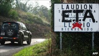 Car drives past road sign overwritten 'Eta'