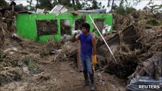 A resident drinks water next to his damaged house after Hurricane Karl hit in Cascajal near Veracruz