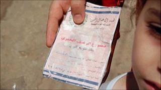 Palestinian refugee holds ration book