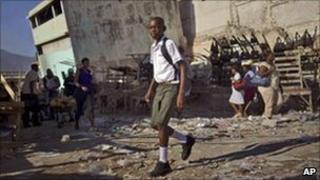 A student walks past damaged buildings in Haiti's capital Port-au-Prince. Photo: October 2010