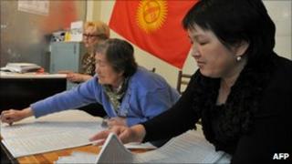 Kyrgyz women prepare forms at a polling station in Osh on 9 October 2010