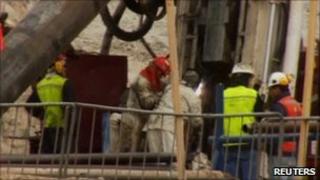 Engineers lower metal tubing into the mine shaft (10 Oct 2010)