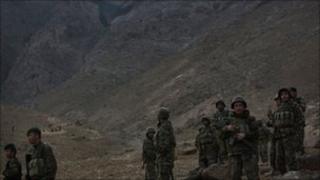 Afghan soldiers stand guard near the site of a plane crash, on the mountain side above them, east of Kabul, Afghanistan, Wednesday Oct. 13, 2010.