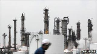 A worker is seen in front of chimneys at an industrial area near Tokyo