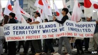 Protesters carry a banner and national flags during an anti-China demonstration march in Tokyo, 16 October 16 2010.