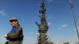 A man stands in front of the Peter the Great statue in Moscow