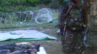 На снимке, опубликованном Глобальным тамильским форумом, виден шриланкийский солдат рядом с телами
