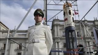 A police officer stands guard by the capsule outside the presidential palace in Santiago