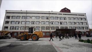 Vehicles stand outside a building inside the Chechen parliamentary compound after the attack, 19 October