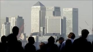 Workers silhouetted in front of the Canary Wharf skyline