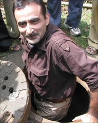 A reporter examining one of the entrances to the tunnel-like structure