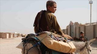 Displaced boy returning to Mukhtar camp with his shopping