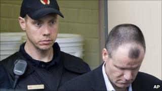 Russell Williams being led away by a police officer