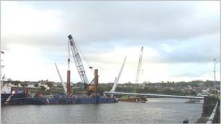 The 1000 tonne barge, the Forth Atlas, at the construction site as the first sections of the bridge are put in place
