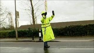 Lollipop lady stopping traffic