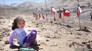 Young girl playing on hillside overlooking Camp Esperanza