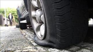 Slashed tyre on car