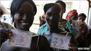 Voters show their electoral cards as they wait to vote in Conakry. Photo: 7 November 2010