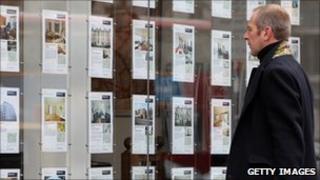 Man looking in an estate agent's window