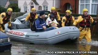 Rescue crews with woman and baby in a lifeboat