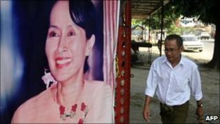 An NLD member walks past a picture of Aung San Suu Kyi as he arrives at the NLD headquarters in Rangoon