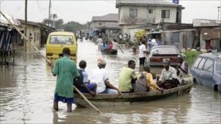 People in a canoe on a street in Cotonou