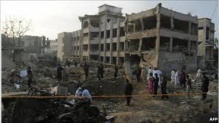 Pakistani investigators inspect the site of a bomb blast in Karachi a day after the attack (12 November 2010)