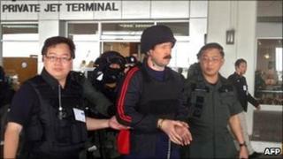 Viktor Bout (centre) is escorted to a plane at Bangkok's Don Mueang airport, Thailand, 16 November 2010