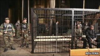 Baktybek Kalyev (R), former defence minister, and ex-deputy chief of security Nurlan Temirbekov sit in a metal cage during a court session