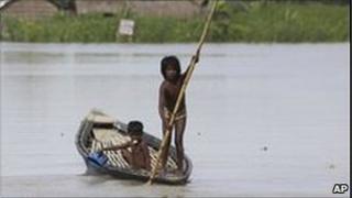 A minor girl paddles a country boat at Kakadhowa village in lower Assam, 100 kilometers (69 miles) west of Gauhati, India, Monday, July 6, 2009