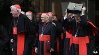 Cardinals take shelter from the rain as they leave a meeting at the Vatican, 19 November 2010