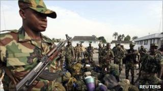 Soldiers wait before being deployed to secure the presidential election process at the army headquarters in Abidjan November 22, 2010