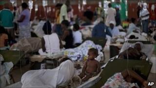 A child sits next to her sick mother at a cholera treatment centre in Cap Haitien