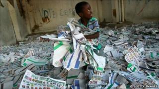 A child plays among election ballots at the site of a polling station in Port-au-Prince (29 November 2010)