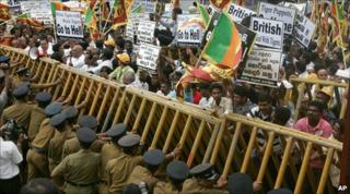 Sri Lankan policemen try to support a barricade during a protest outside the British embassy in Colombo on 3 December 2010