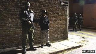 A soldier escorts the suspect in Cuernavaca December 3, 2010.