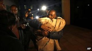 Relatives of Henry Glover embracing