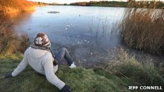 A student looks over the thawing ice at Sandy Water Park, Llanelli