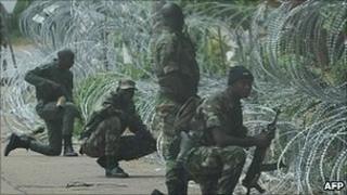 New Forces (FN) fighters adopt defensive combat positions outside the Hotel Golf in Abidjan, 13 December 2010