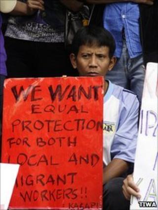 A migrant worker holds a sign calling for equal rights (Photography by Jung-Lung Chang, provide by TIWA)
