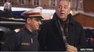 Croatian former Prime Minister Ivo Sanader is escorted by an Austrian policeman in Salzburg after being arrested, 10 December
