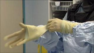 Surgeon putting on glove