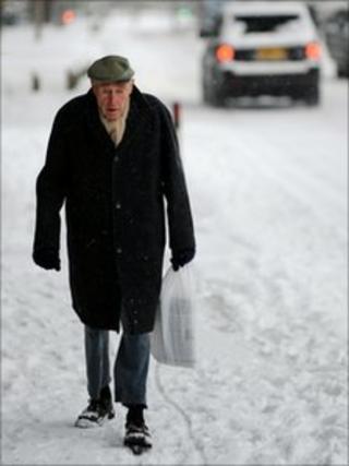 Elderly man walking in snow