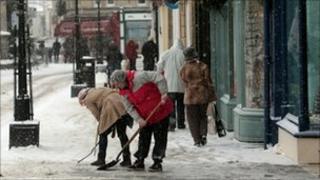Shopkeepers clearing snow in Wells, Somerset
