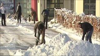 Men shovelling snow in a street