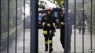 Italian firefighters and a policeman leave the Swiss embassy in Rome, 23 December
