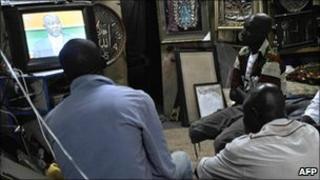 People watch television in Abidjan